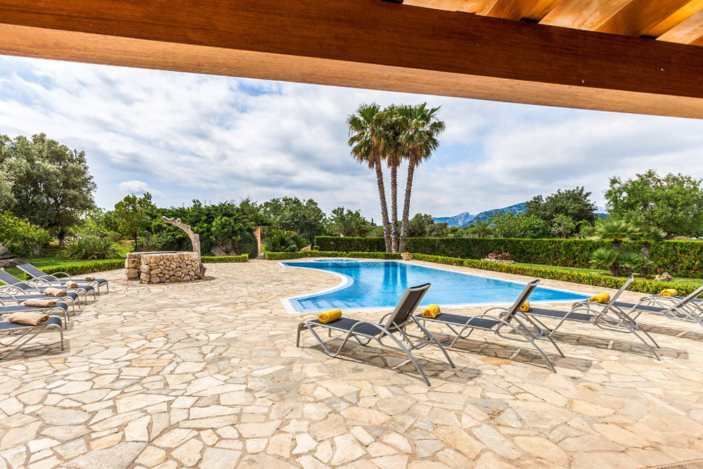 The swimming pool with sun loungers at Villa Les Oliveres in Puerto Pollensa